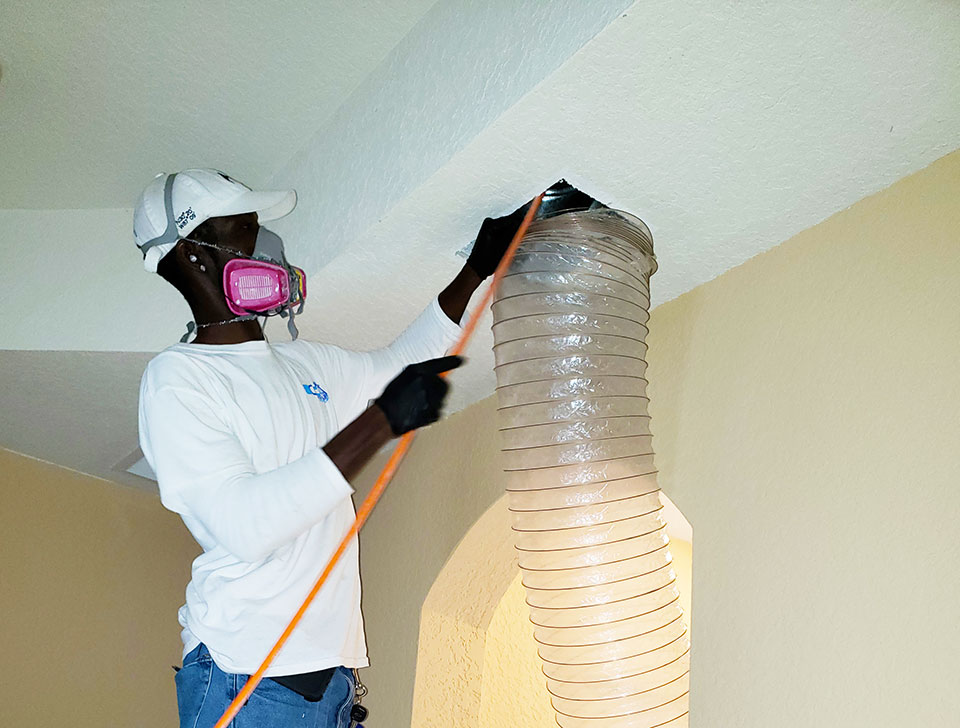 a man performing air duct cleaning for New Homes in Weston, Florida