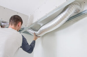 man cleaning the line to a newly installed air duct cleaning service in Boca Raton 